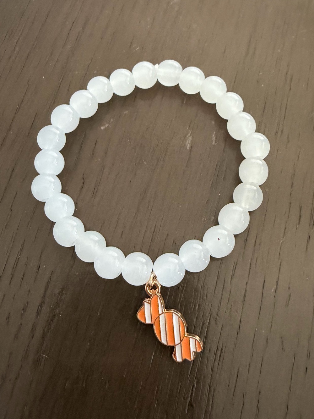 White Beaded Bracelet with Orange Candy Charm Accent